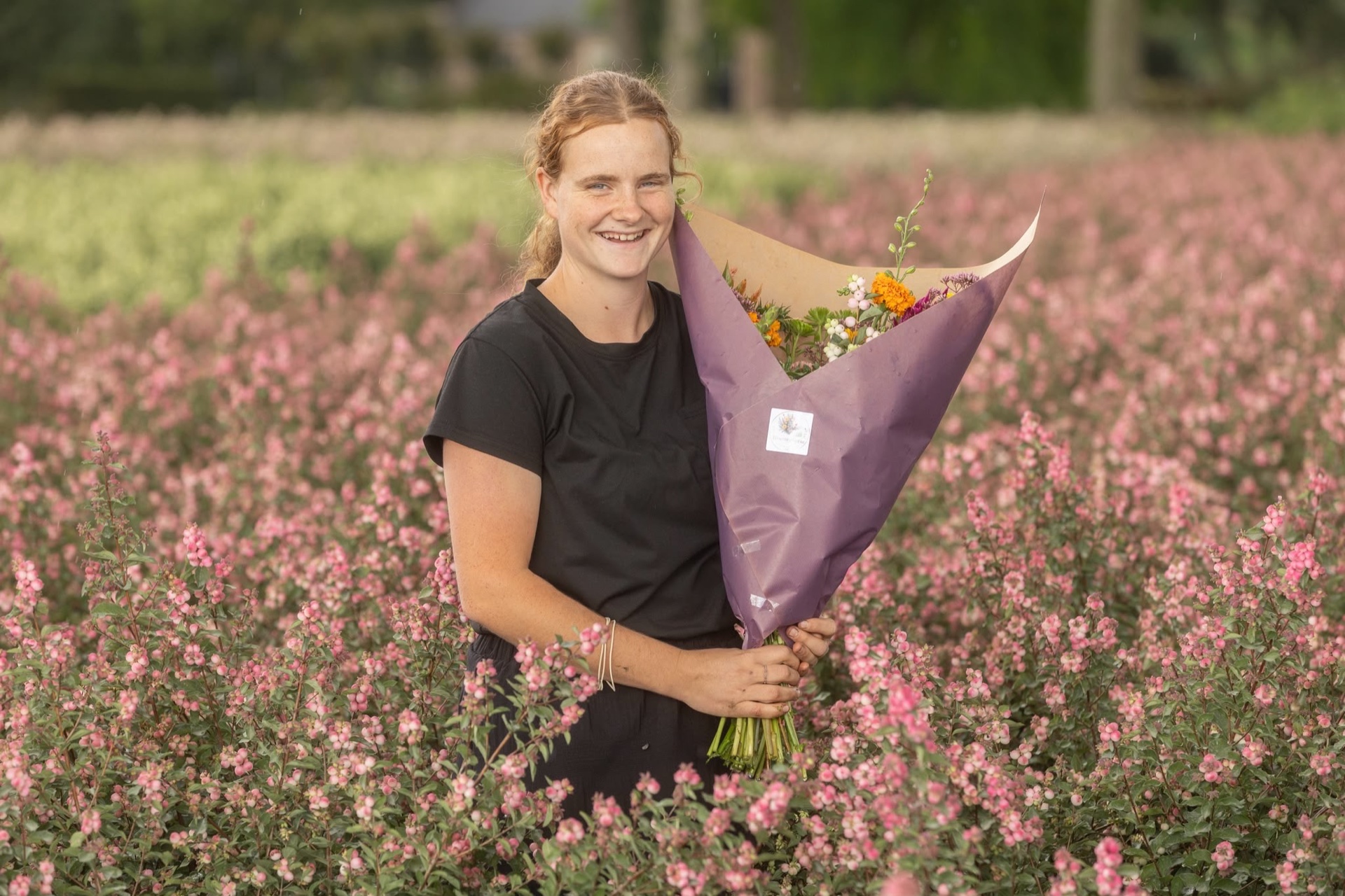 Alida met een biologisch boeket tussen roze bloemen