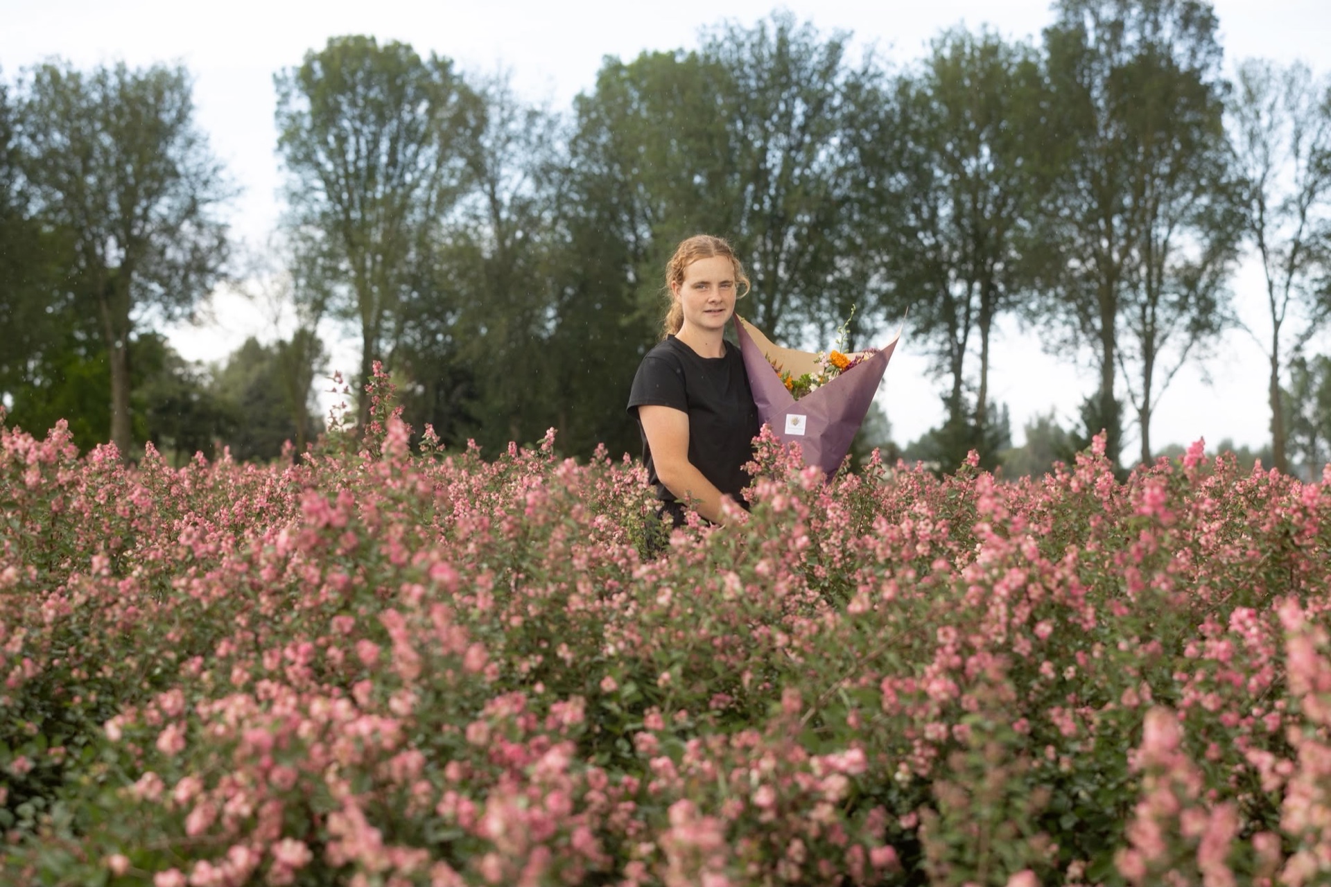 Alida verder in het bloemenveld met een boeket